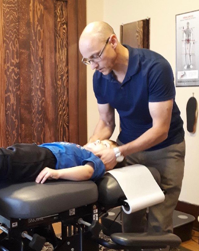 This is a picture of Edmonton chiropractor Dr. Dean Collins treating a child.  Chiropractic care for children is safe and helps ensure a healthy spine and nervous system throughout childhood and adulthood.