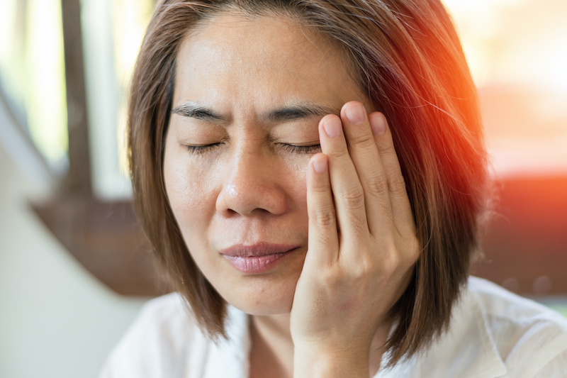 This is a picture of a woman with TMJ pain. Chiropractic treatment for TMJ pain provides a natural and effective treatment option.