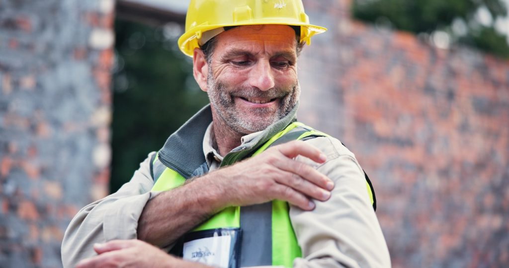This is a picture of a man that has shoulder pain. It depicts the common question people have which is "Why Does My Shoulder Hurt When I Lift My Arm?".