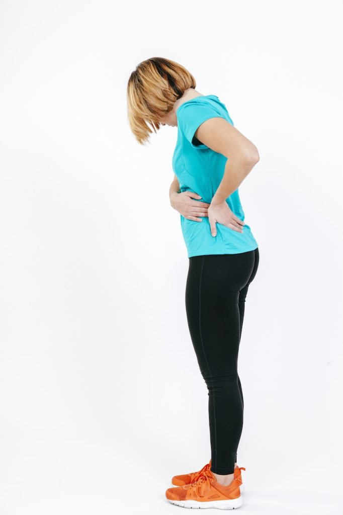 This is a picture of a woman grabbing her low and hip. It depicts how you can have hip from the low back.