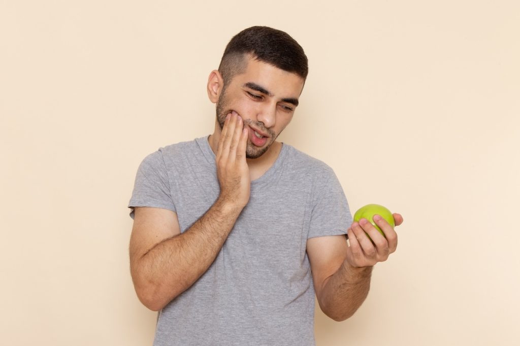 This is a picture of a man whose jaw hurts when he chews and it depicts the title of the post, 'Why Does My Jaw Hurt When I Chew?'