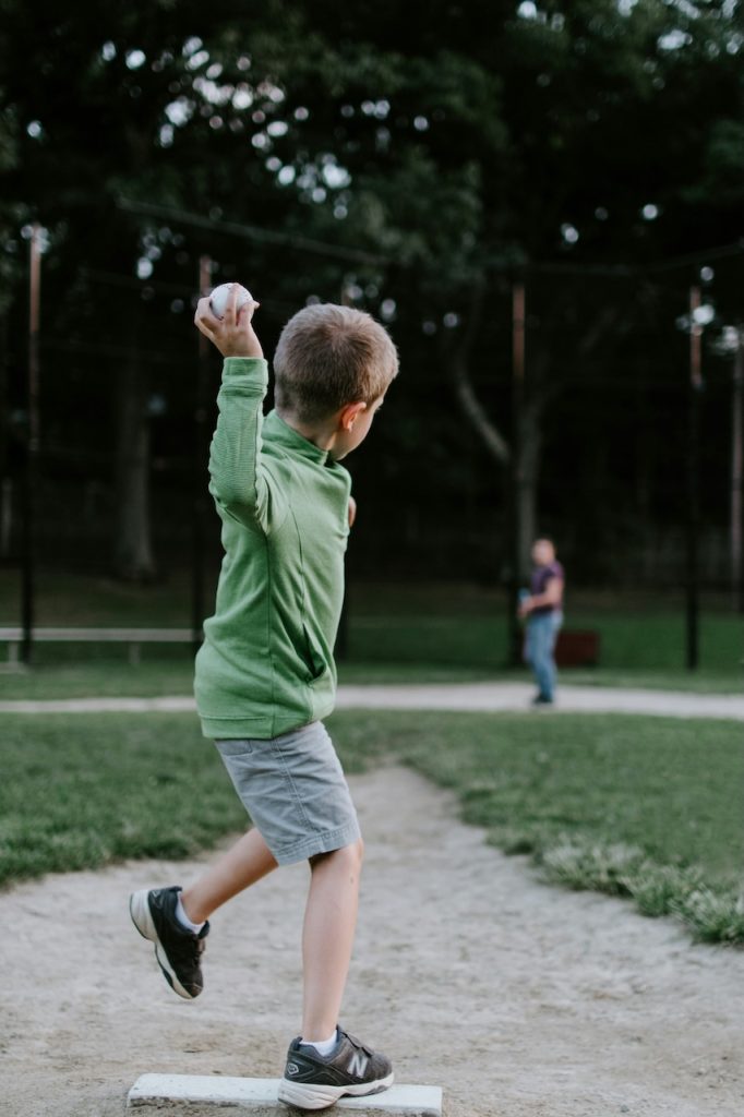 This is a picture of a boy throwing a baseball. It depicts a child athlete with back pain - pediatric chiropractor Edmonton