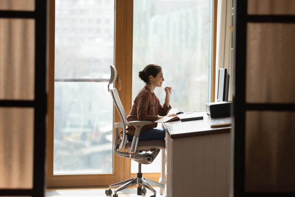 Woman sitting at a desk using good posture while working at a computer